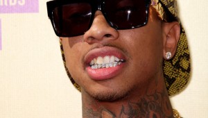 Tyga-supreme-snakeskin-hat-Celine-gold-chain-sunglasses-red-leather-tank-top-Balmain-jeans-red-sneakers-Upscalehype-2